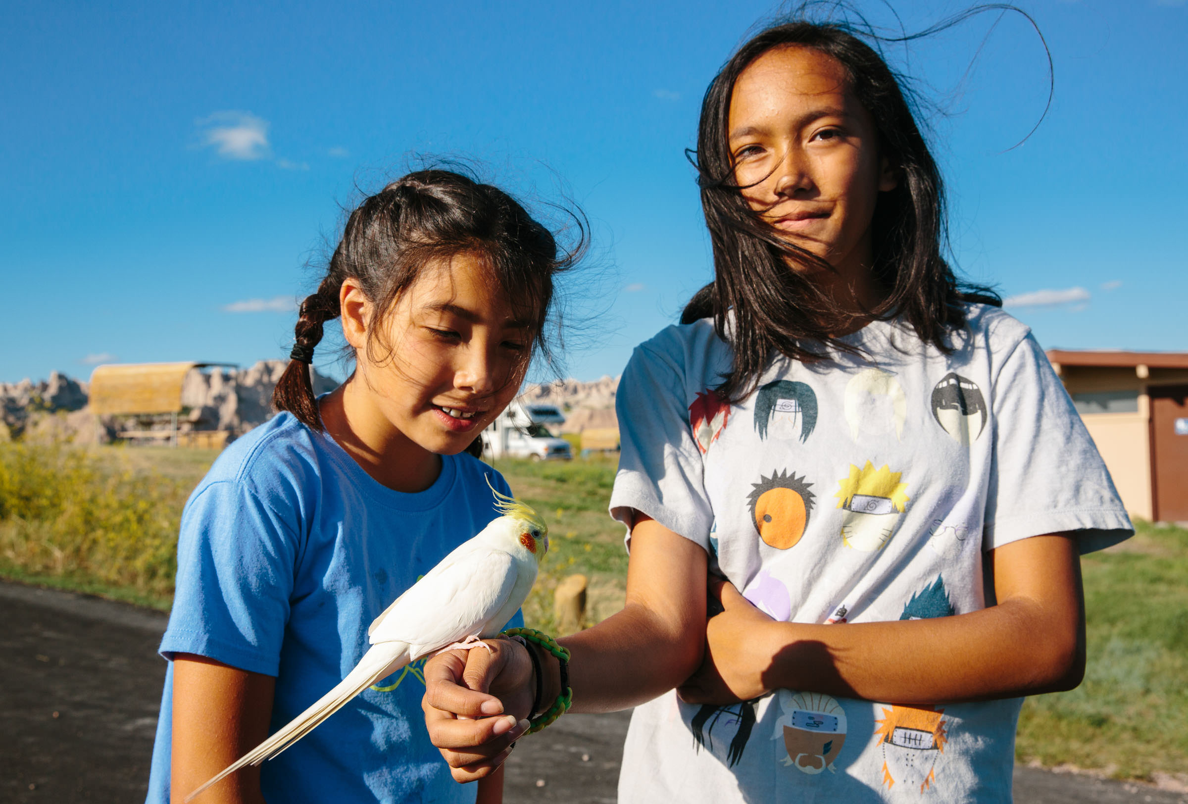 Alhora and Soral walk around with their pet bird in Cedar Pass Campground, Badlands National Park, South Dakota.