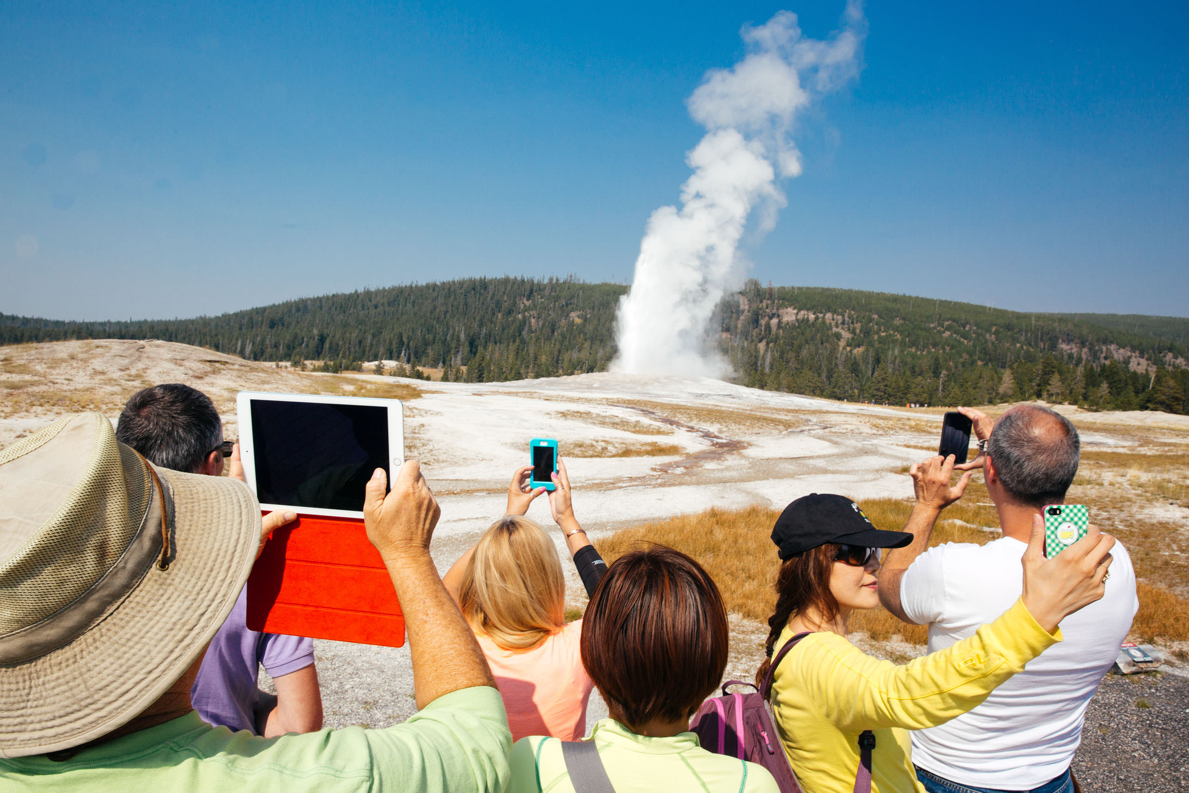 Tourists at Old Faithful Geyser, Yellowstone National Park.