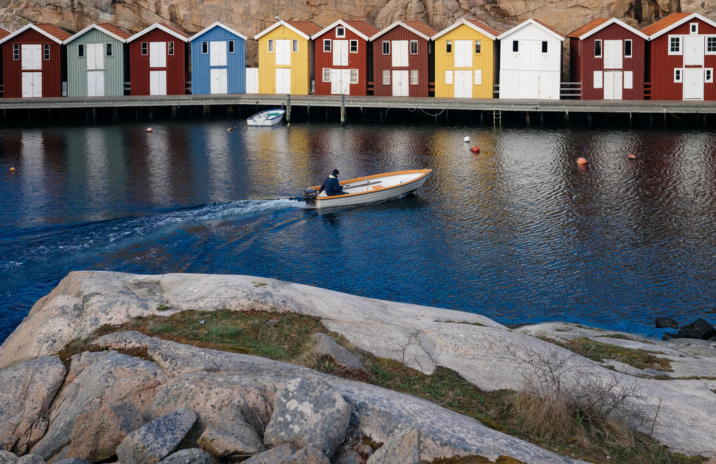 Colorful wooden boat houses along the harbor in Smögen, Sweden.